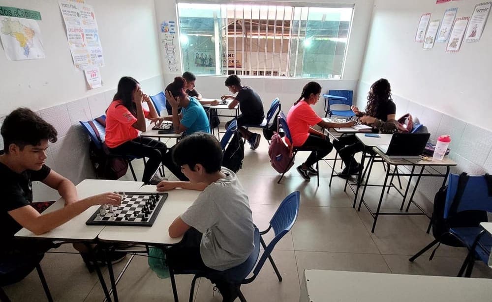 Alunos jogando xadrez em duplas na sala de aula